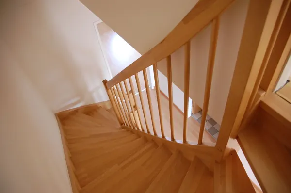 Monte-escalier à Pacé : escalier en bois à quart-tournant, cas typique du rail courbe sur mesure